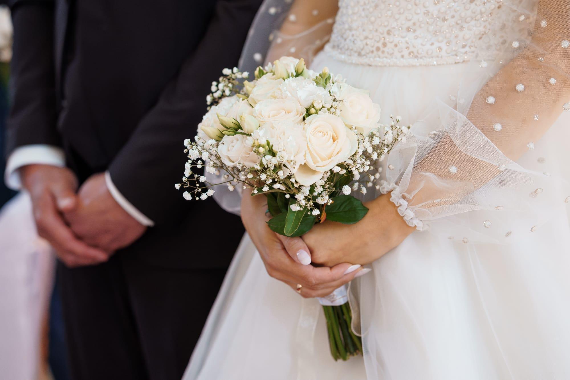 結婚式で白いブーケを持つ新婦と新郎