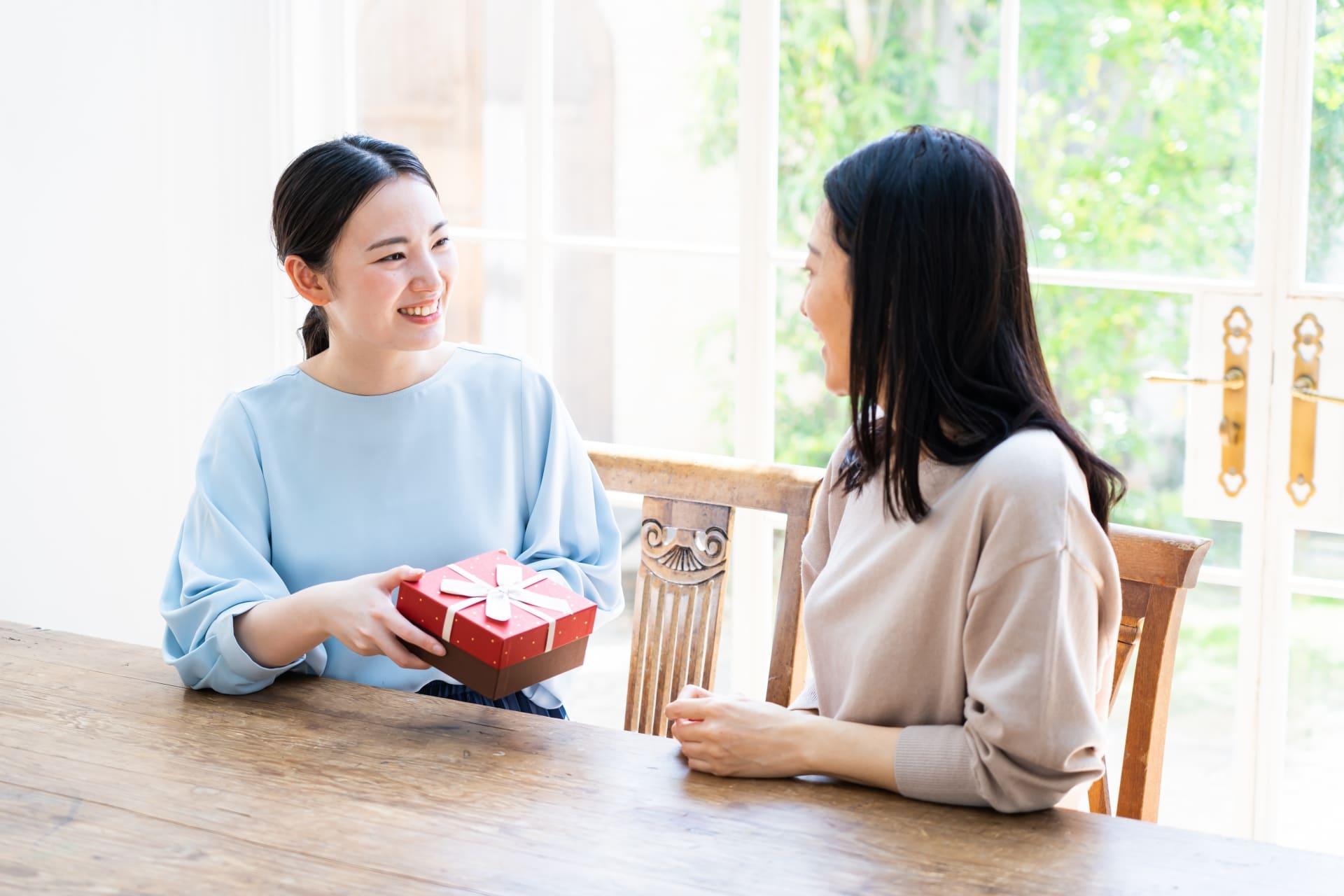 母に誕生日プレゼントを渡す女性